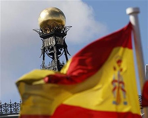 A Spanish flag flutters in the wind in front of the dome of Bank of Spain headquarters in central Madrid.