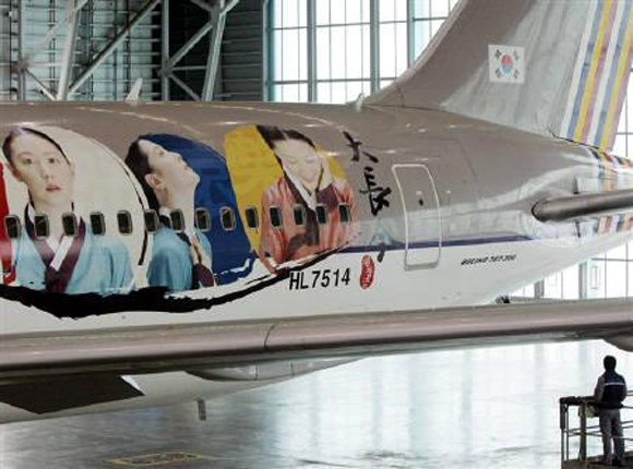 A South Korean looks around the Asiana Airlines plane that had been wrapped with images of heroine Lee Young-ae in Inchon, west of Seoul.