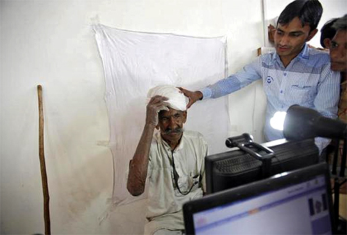 A villager gets ready to be photographed for the Unique Identification (UID) database system at an enrolment centre at Merta district in Rajasthan.