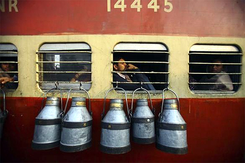 Empty milk containers hang from the window of a train in Uttar Pradesh.