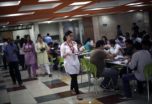 An employee carries her lunch at a cafeteria inside Tech Mahindra office building in Noida on the outskirts of New Delhi.