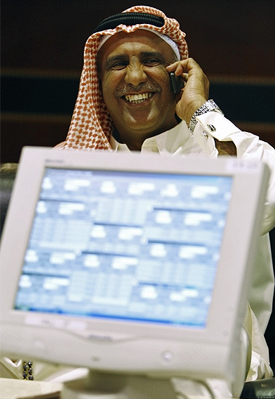 A trader speaks on the phone as he monitors stocks at the Dubai Stock Exchange in the Dubai World Trade Center.