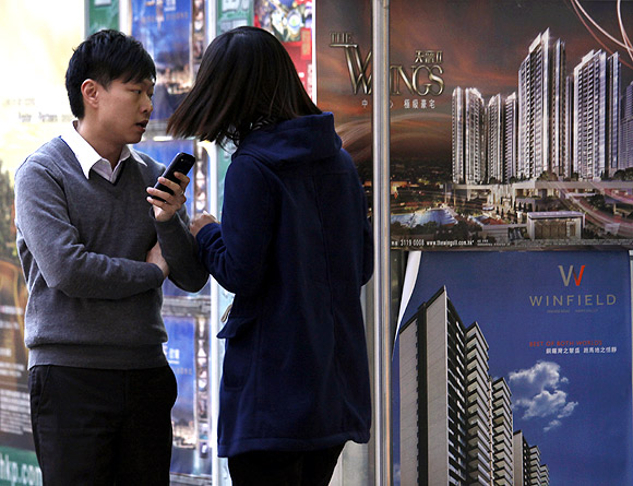 Property sales agents chat at their office in Hong Kong.