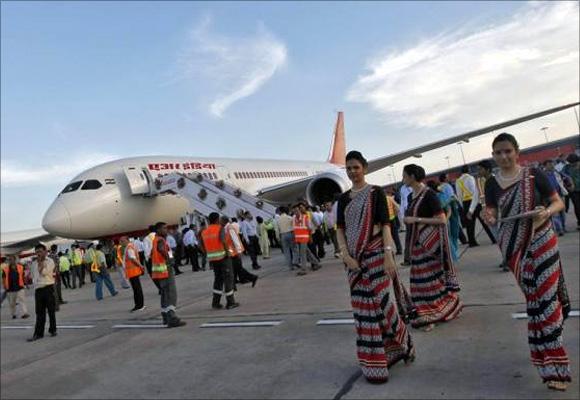 Air hostesses walk next to the parked Air India's Boeing 787-800 Dreamliner upon its arrival at the airport in New Delhi.