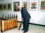 A 1998 file photo of Sir Donald Bradman holding one of his old cricket bats 