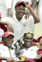 West Indies captain Brian Lara (C) poses with teammates Fidel Edwards (L) and Jerome Taylor (R) and the Clive Lloyd trophy