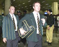 Herschelle Gibbs (left) and a South African team member pass police officials on arrival at Lahore airport
