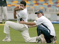 Zaheer is seen stretching with physiotherapist Andrew Leipus at the Brisbane Cricket Ground in December 2003.