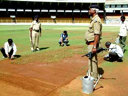 Workers prepare the main pitch at the Motera Stadium in Ahmedabad under heavy security