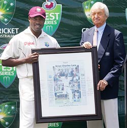 Brian Lara is presented with a photograph commemorating his world record Test run tally by commentator and former Australian cricketer Richie Benaud