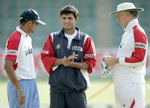 Sourav Ganguly talks with teammate Rahul Dravid (L) and coach Greg Chappell (R) at a practice session at the Harare Sports Club