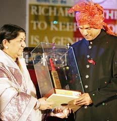 Lata Mangeshkar presents a golden bat to Sachin Tendulkar