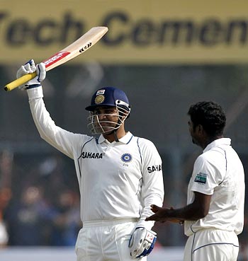 Virender Sehwag celebrates his century in the second Test in Kanpur as Muttiah Muralitharan applauds