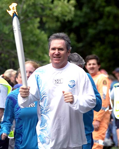 Australian cricket legend Allan Border carries the Olympic torch in Toowong on June 14, 2000.