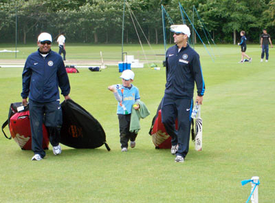 Coach Gary Kirsten walks back after the practice session along with his son
