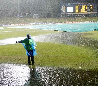 A member of the ground staff stands in the rain