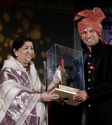 Bollywood singer Lata Mangeshkar presentsSachin Tendulkar with a golden bat during a felicitation ceremony in Mumbai