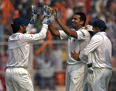 Zaheer is congratulated by captain Dhoni and Gautam Gambhir after Smith's dismissal