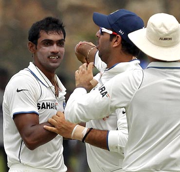 Abhimanyu Mithun (left) is congratulated by team mates after taking the wicket of Tillakaratne Dilshan