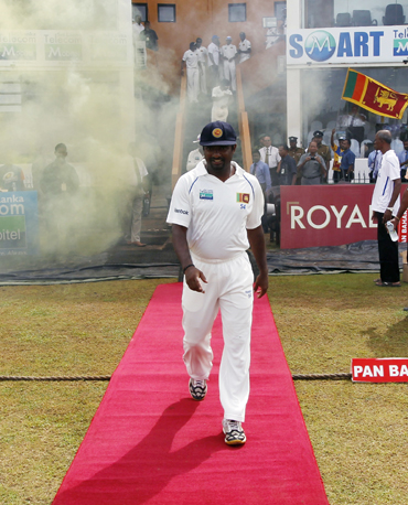 Muralitharan walks to the field on the fifth day of the first Test