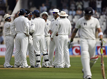 Indian players celebrate the dismissal of New Zealand's Brendon McCullum (right)