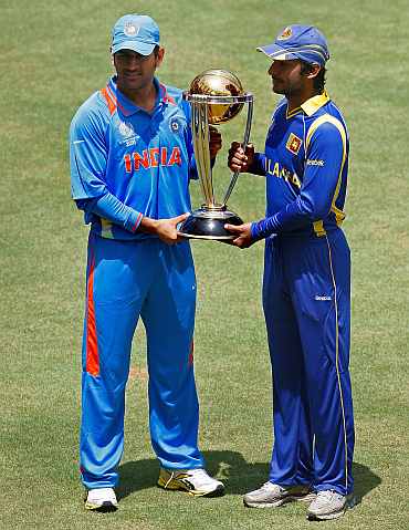 MS Dhoni and Kumar Sangakkara pose with the World Cup trophy at Wankhede Stadium