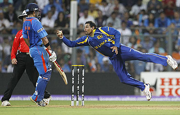 Tillakaratne Dilshan (right) dives full stretch to take a successful return catch to dismiss Kohli