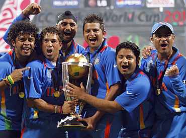 Tendulkar and members of the Indian team celebrate with the trophy.