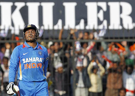 Virender Sehwag celebrates scoring a century during the fourth One-day against the West Indies in Indore