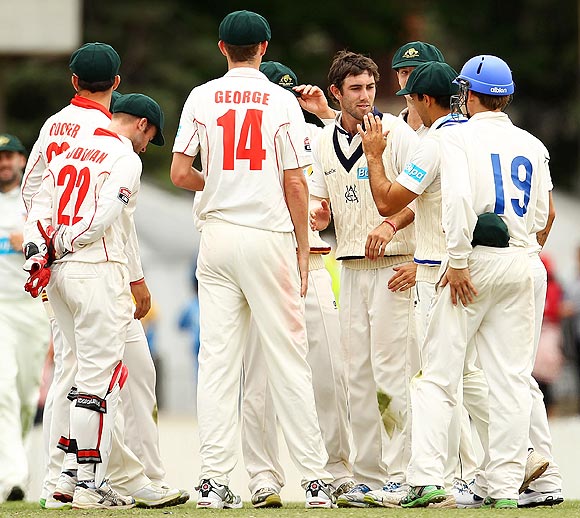 Cameron Boyce of the Chairman's XI is congratulated by teammates after dismissing Virat Kohli