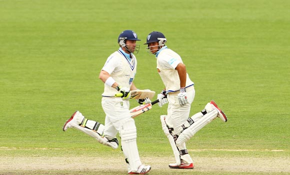 Phillip Hughes (left) and Usman Khawaja run between the wickets