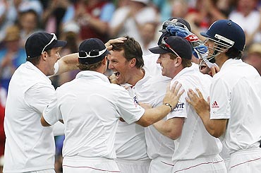 England's Graeme Swann (3rd from left) is congratulated by teammates after dismissing Usman Khawaja on Monday