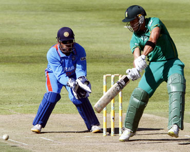 South Africa's Faf du Plessis (R) plays a shot as India's keeper MS Dhoni looks on during their third one-day international cricket match in Cape Town