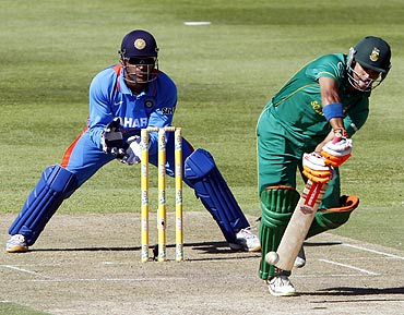 South Africa's JP Duminy (R) plays a shot as India's keeper MS Dhoni looks on during their third one-day international cricket match in Cape Town