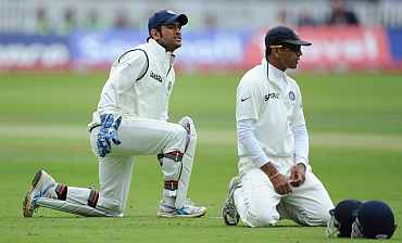 MS Dhoni (left) and Rahul Dravid react after dropping Jonathan Trott