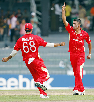 Canada's Harvir Baidwan (right) celebrates with teammate Jimmy Hansra after dismissing Younis Khan
