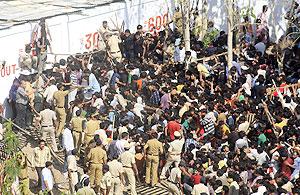 A crowd of fans rushes towards ticket windows as police try to control them outside the Vidarbha Cricket Association Stadium in Nagpur on Tuesday