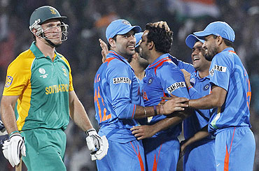 Graeme Smith (left) walks off the field after he was dismissed by Zaheer Khan (centre)