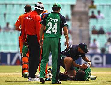 George Dockrell of Ireland receives treatment to his right shoulder after trying to stop a ball to the boundary