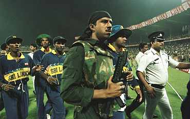 Riot police lead the Sri Lankan team off the pitch after the abandonment of the semi-final in the Cricket World Cup between India and Sri Lanka