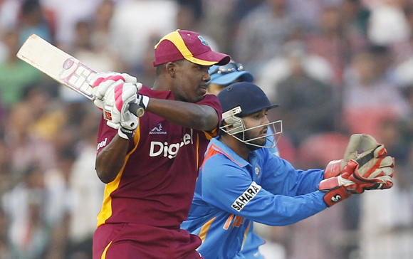West Indies' Darren Bravo (L) hits a shot as India's wicketkeeper Parthiv Patel fields during their first one-day international match in Cuttack