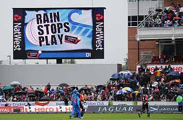 The players leave the field as rain stops play during the NatWest One Day International between England and India