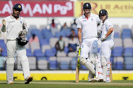 Kevin Pietersen and Jonathan Trott look on as MS Dhoni sets the field