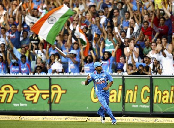 Gautam Gambhir celebrates after taking the catch to dismiss David Warner