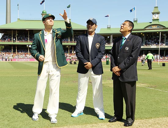 Australia captain Michael Clarke tosses the coin as Mahendra Singh Dhoni looks on