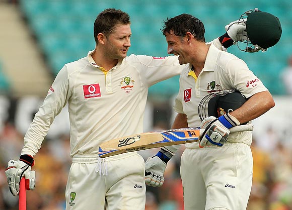Michael Clarke (left) hugs teammate Michael Hussey at the close of play