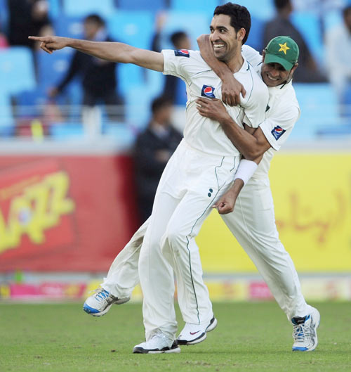 Umar Gul of Pakistan celebrates with Abdur Rehman after dismissing Jonathan Trott of England during the first Test match