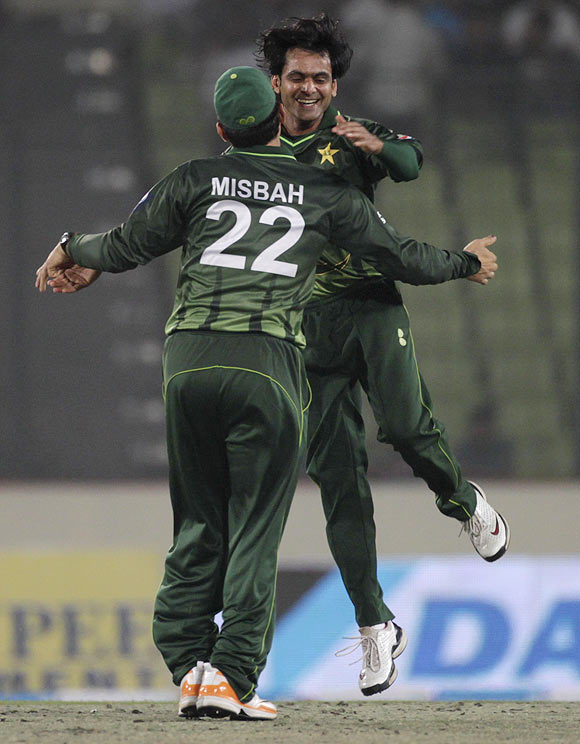 Pakistan's captain Misbah-ul-Haq congratulates Mohammad Hafeez (right) after picking a wicket