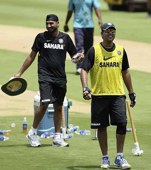 India's Yuvraj Singh smiles as he walks with teammate Harbhajan Singh during a practice session ahead of their first Twenty20 cricket match against New Zealand in Visakhapatnam