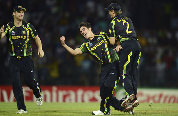 Australia's Pat Cummins celebrates with teammates George Bailey (R) and Cameron White (L) after the dismissal of India's Virat Kohli